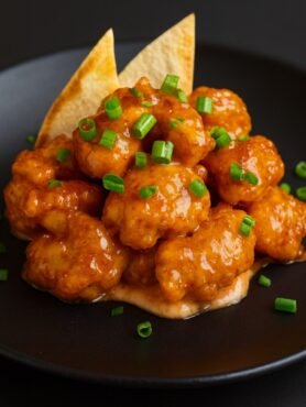 Crispy golden shrimp coated in a creamy spicy dynamite sauce and topped with green onions.