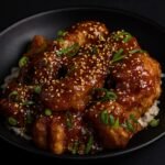 Golden fried chicken pieces coated in a glossy sweet-spicy General Tso’s sauce with broccoli.