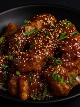 Golden fried chicken pieces coated in a glossy sweet-spicy General Tso’s sauce with broccoli.