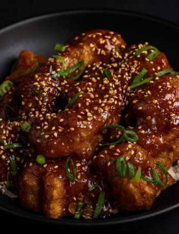 Golden fried chicken pieces coated in a glossy sweet-spicy General Tso’s sauce with broccoli.