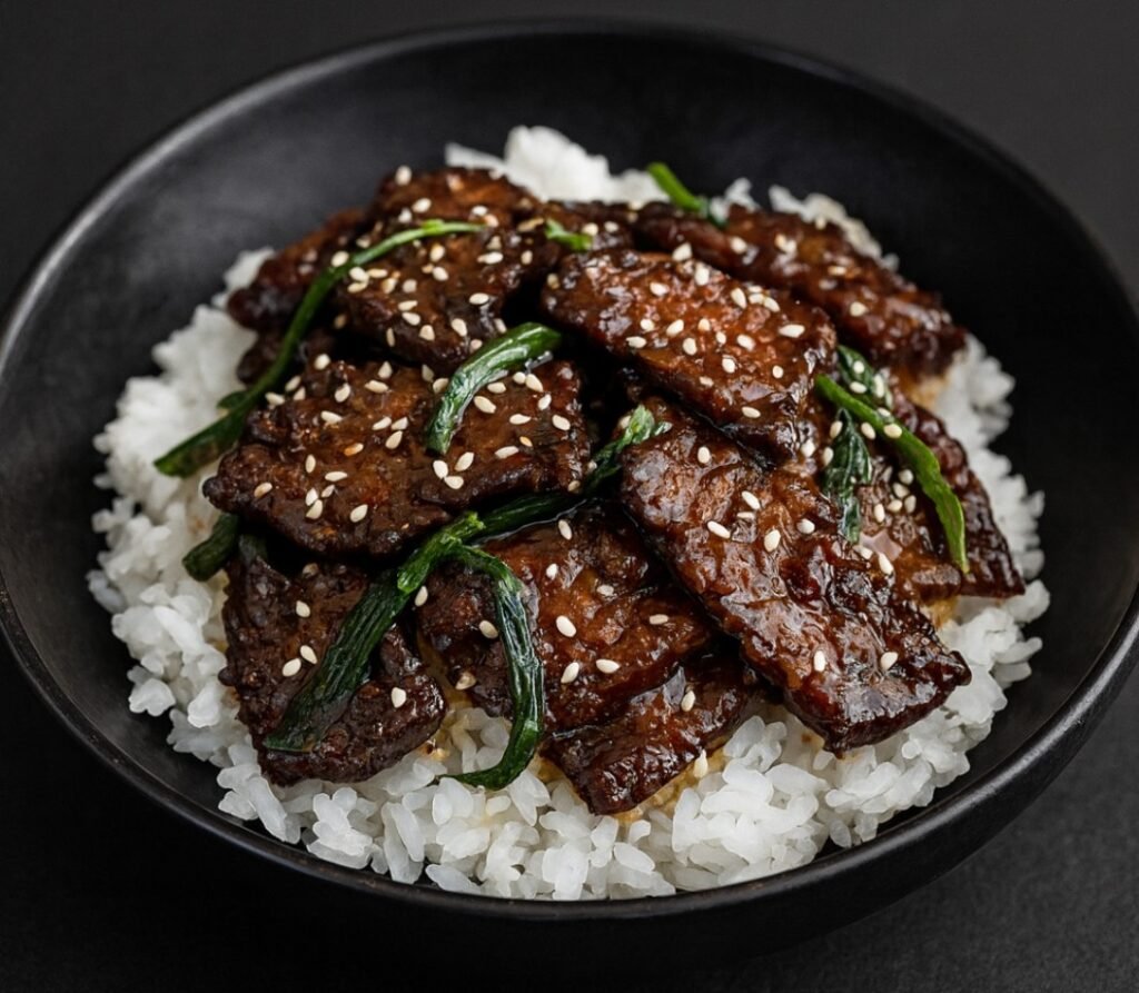 Crispy seared beef strips coated in a glossy soy garlic sauce with green onions.