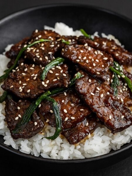 Crispy seared beef strips coated in a glossy soy garlic sauce with green onions.