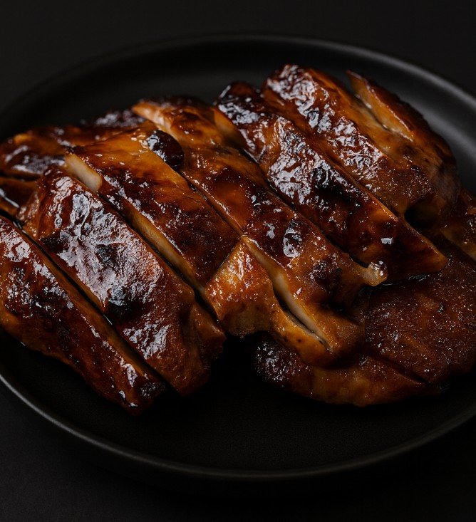 Juicy grilled chicken thighs sliced and glazed with a thick teriyaki sauce, topped with green onions.