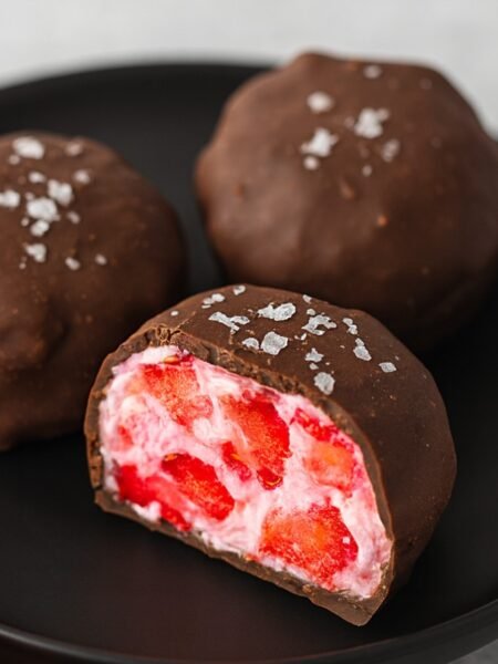 Strawberry yogurt bites recipe with frozen strawberries coated in creamy yogurt and chocolate drizzle