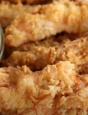 Golden fried chicken tenders from Chili’s Crispy Chicken Crispers copycat recipe, served with fries and dipping sauces.