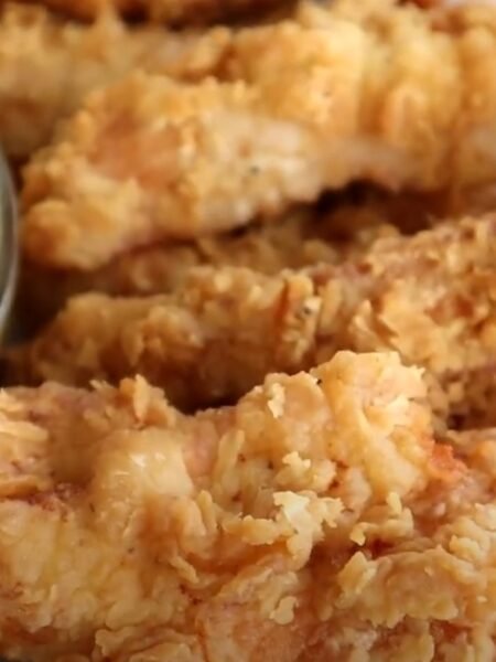 Golden fried chicken tenders from Chili’s Crispy Chicken Crispers copycat recipe, served with fries and dipping sauces.