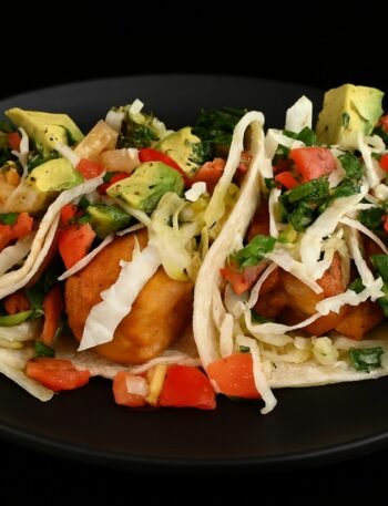 Crispy cod fish tacos served in corn tortillas with creamy cabbage slaw and chipotle-lime crema – fresh Baja-style recipe.